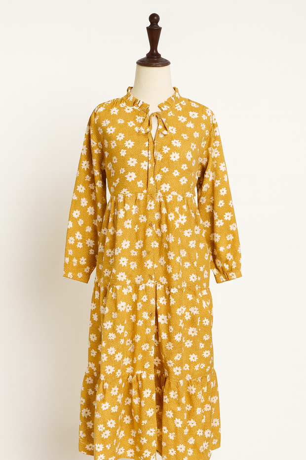 Yellow floral dress on a mannequin against a white background